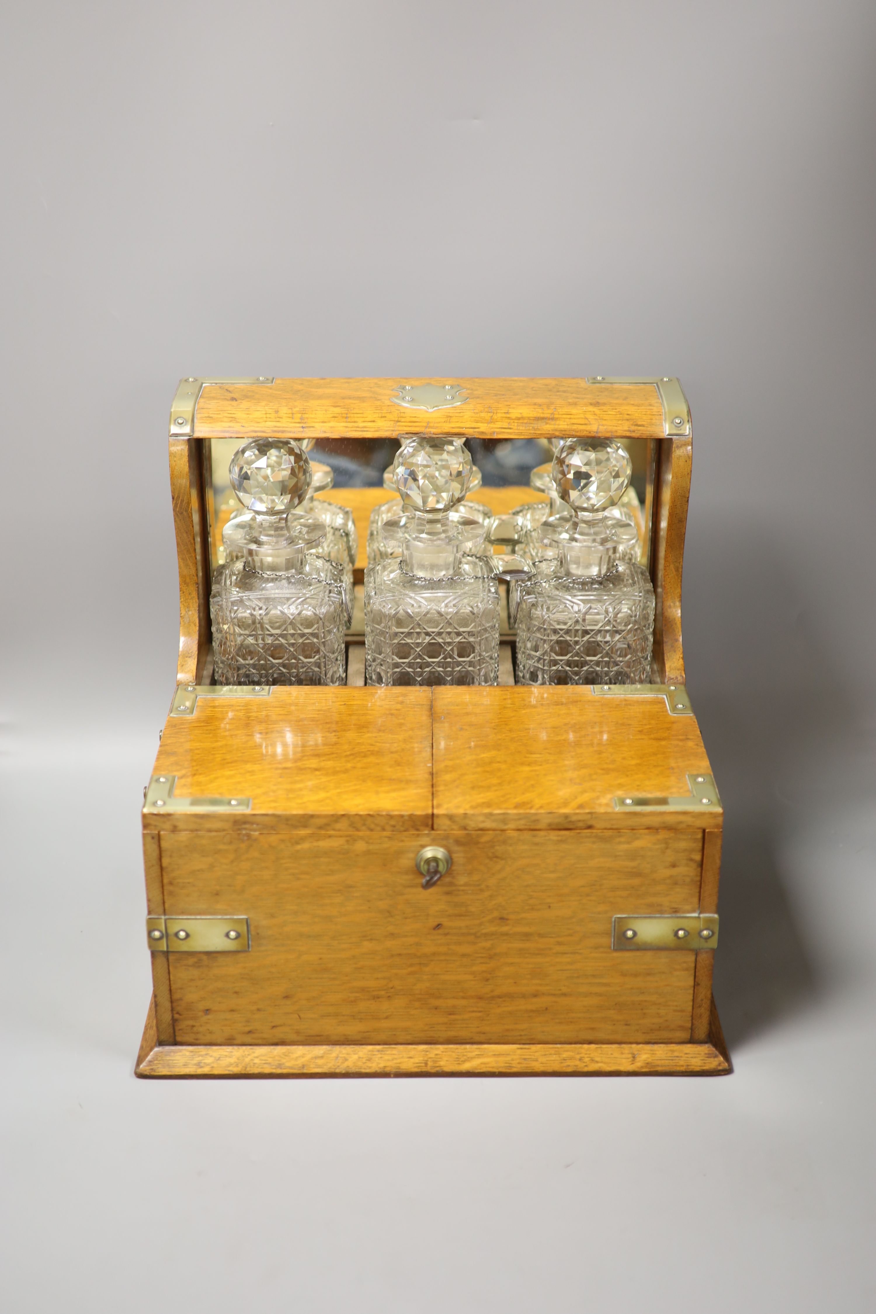 A good Victorian oak and brass mounted tantalus and combination games box, height 35.5cm width 36cm depth 30cm